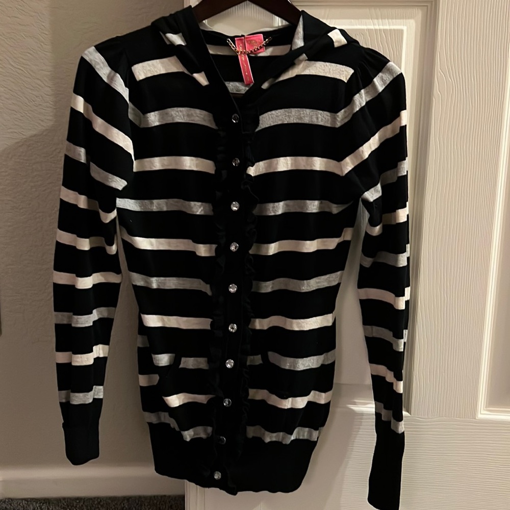 Charlotte Tarantola hoodie sweater with jewel like buttons and ruffle placket.